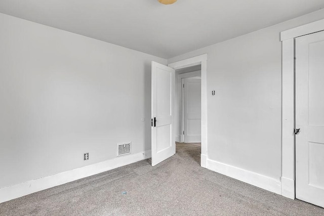 unfurnished bedroom featuring carpet flooring, visible vents, and baseboards