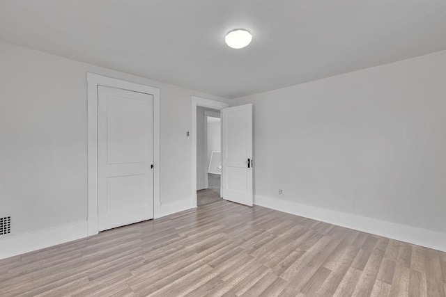 spare room with light wood-style floors and baseboards