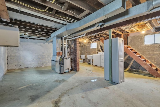 basement featuring heating unit, stairs, and separate washer and dryer