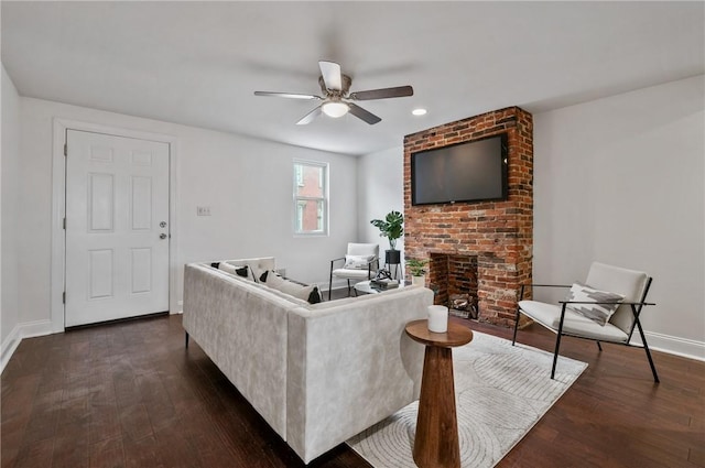 living room with dark wood-style floors, a fireplace, baseboards, and ceiling fan