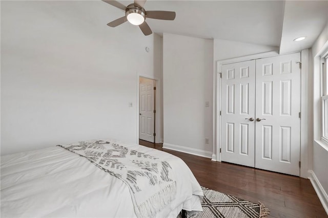 bedroom with lofted ceiling, a ceiling fan, baseboards, a closet, and dark wood-style floors