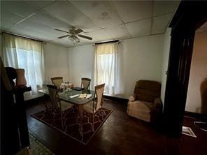 dining room featuring a wealth of natural light, ceiling fan, a paneled ceiling, and wood finished floors