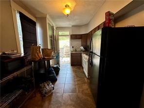 kitchen featuring freestanding refrigerator and dark tile patterned floors