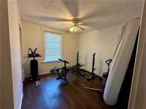 workout area featuring dark wood-type flooring and a ceiling fan