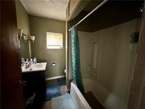 bathroom featuring baseboards, toilet, vanity, and shower / tub combo with curtain