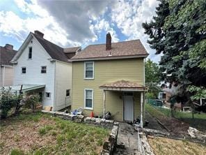 rear view of property featuring a chimney