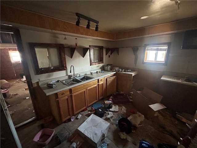 kitchen featuring brown cabinets, a sink, and light countertops