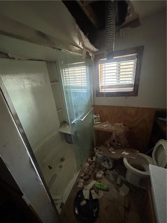 full bath with a shower stall, toilet, and wooden walls