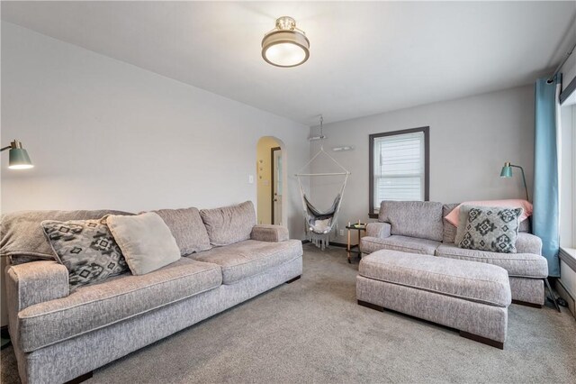 carpeted living room with arched walkways