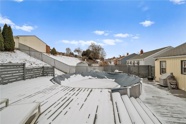 snow covered deck featuring a fenced backyard