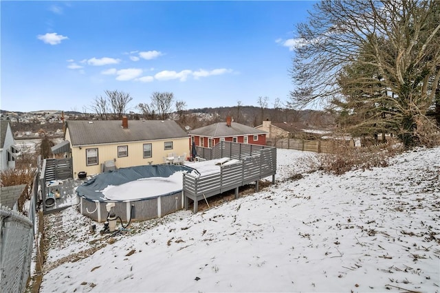 snow covered property with a covered pool and fence