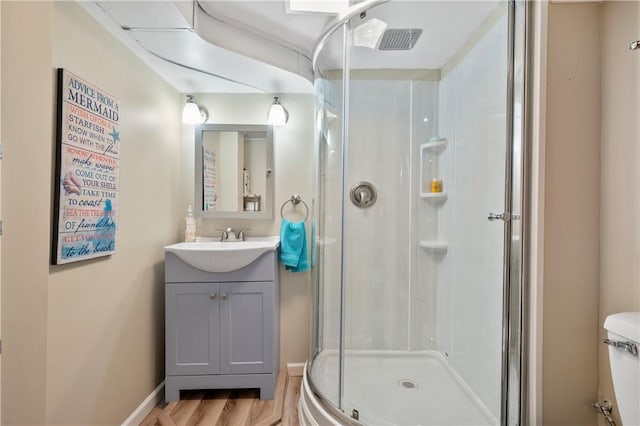 full bath with visible vents, toilet, wood finished floors, vanity, and a shower stall