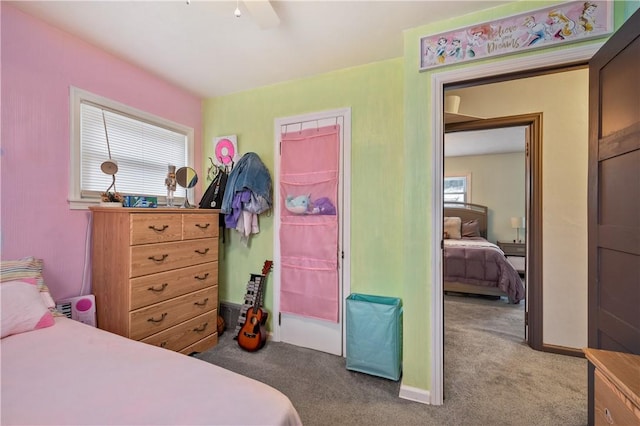 carpeted bedroom with ceiling fan and baseboards