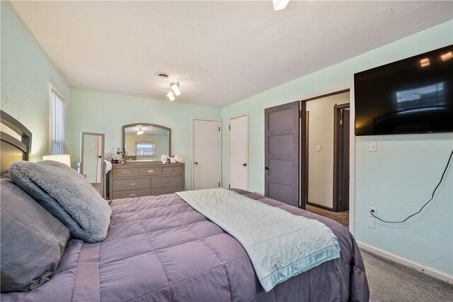 carpeted bedroom featuring arched walkways, visible vents, and baseboards