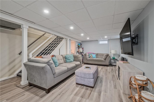 living area with a drop ceiling, stairway, light wood-type flooring, and recessed lighting