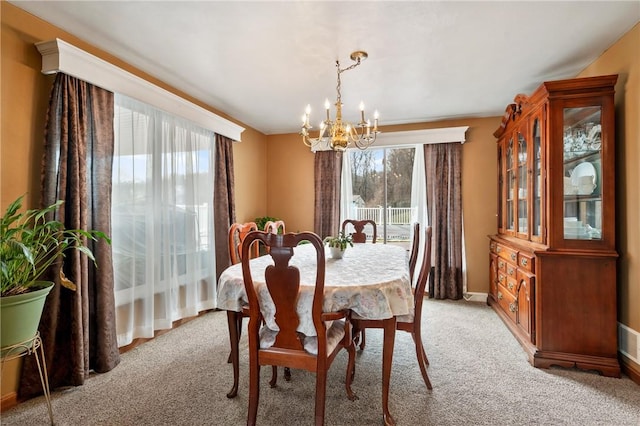 dining space with light carpet, visible vents, a chandelier, and baseboards