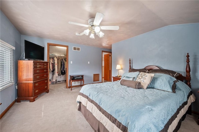 bedroom featuring lofted ceiling, light colored carpet, visible vents, a spacious closet, and a closet