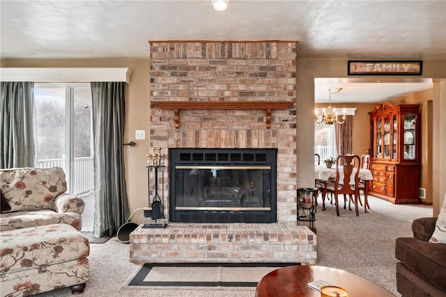 carpeted living area with a fireplace and a notable chandelier