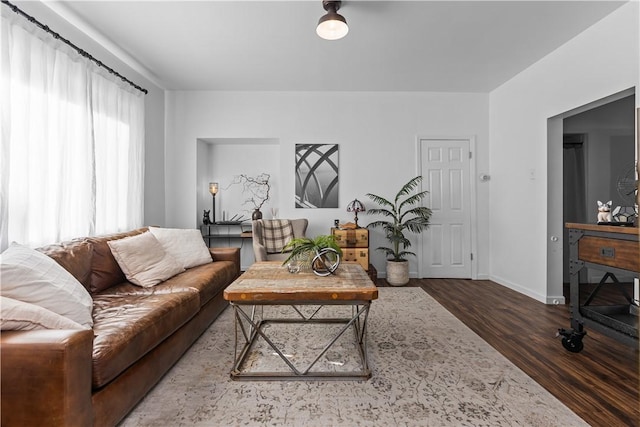 living area with baseboards and wood finished floors