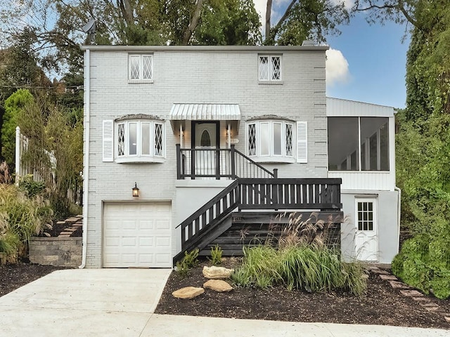 view of front of home with brick siding, driveway, stairway, and an attached garage