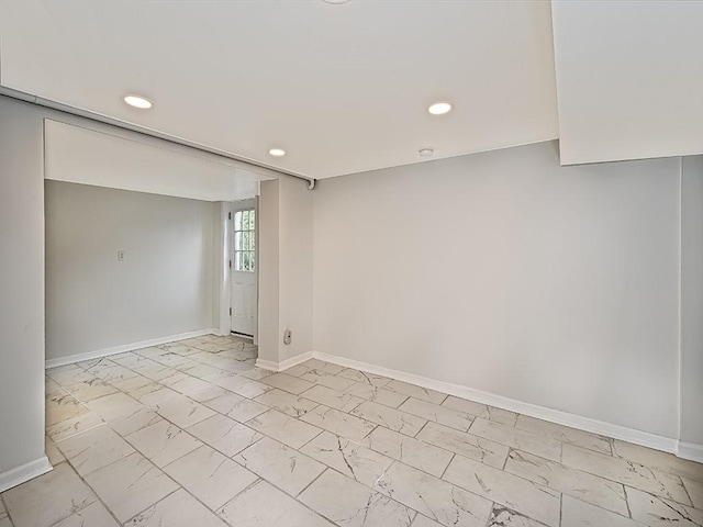 unfurnished room with recessed lighting, marble finish floor, and baseboards