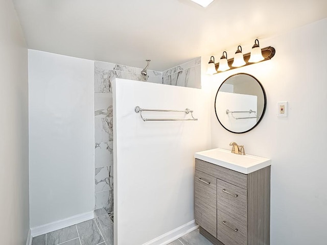 bathroom with marble finish floor, baseboards, a walk in shower, and vanity