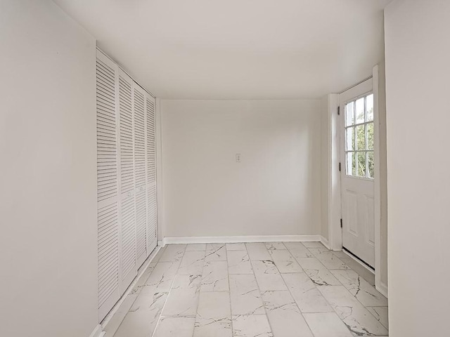 foyer featuring marble finish floor and baseboards