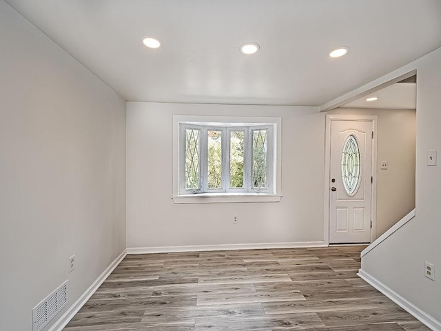 foyer featuring baseboards, visible vents, wood finished floors, and recessed lighting