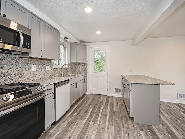 kitchen featuring light wood finished floors, visible vents, appliances with stainless steel finishes, and gray cabinetry