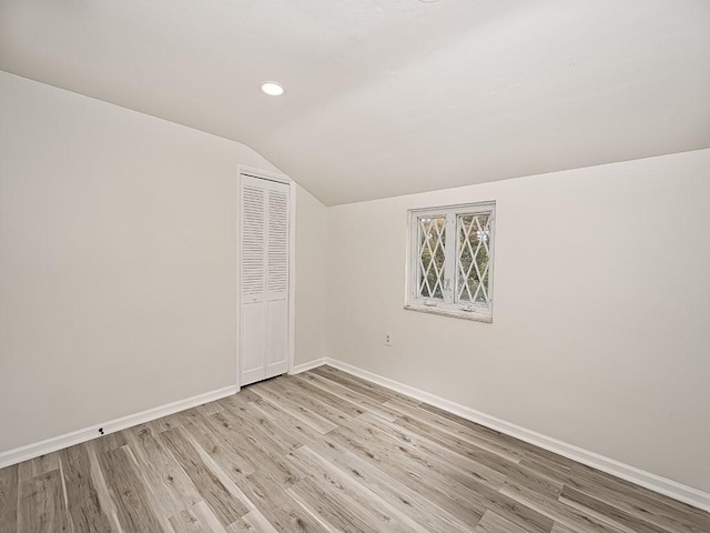 interior space with light wood-type flooring, vaulted ceiling, baseboards, and recessed lighting