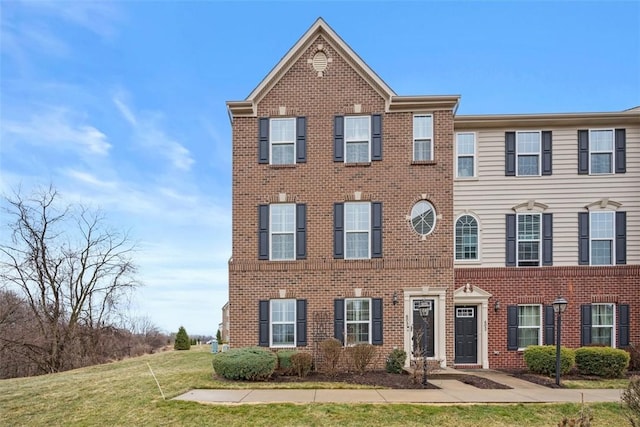 view of front of home featuring brick siding and a front lawn