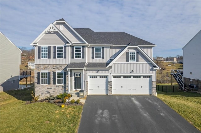 view of front of property with stone siding, aphalt driveway, board and batten siding, and a front yard