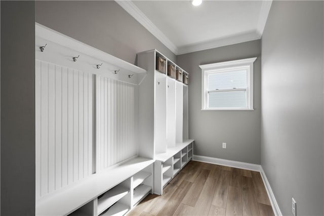 mudroom with light wood-style flooring, baseboards, and crown molding