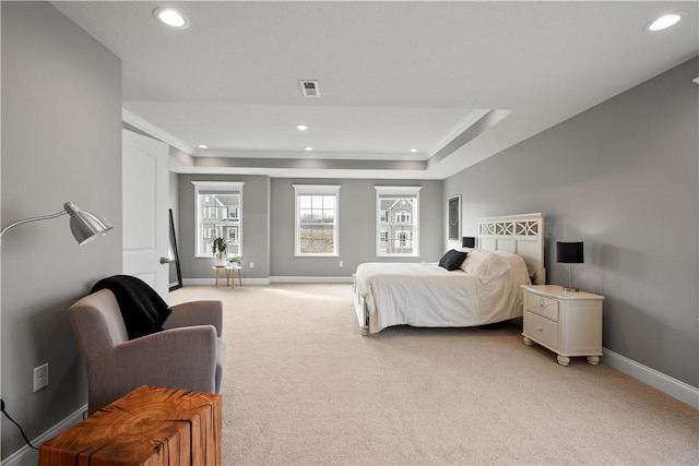 bedroom with baseboards, a tray ceiling, visible vents, and light colored carpet