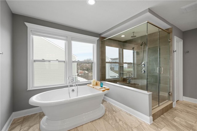 full bath featuring a freestanding tub, a shower stall, baseboards, and recessed lighting