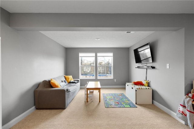 living area with carpet floors, visible vents, and baseboards