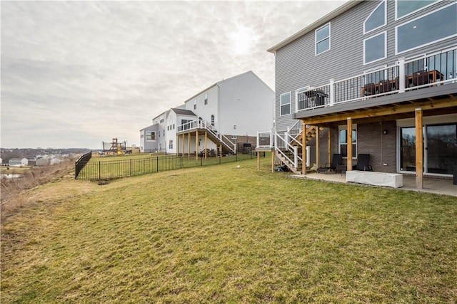 view of yard with a deck, a patio, fence, and stairs