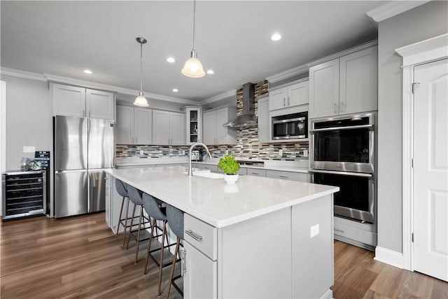 kitchen with stainless steel appliances, wine cooler, ornamental molding, and wall chimney exhaust hood