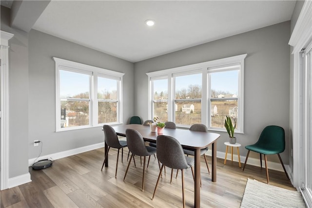 dining area with light wood-style floors and baseboards