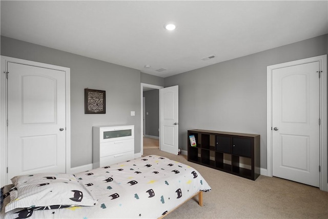 carpeted bedroom with visible vents and baseboards