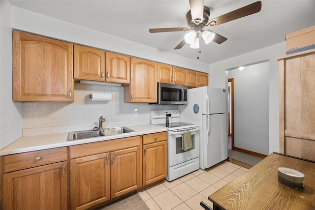 kitchen with light tile patterned flooring, white appliances, a sink, light countertops, and tasteful backsplash