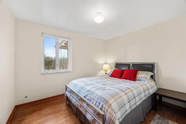 bedroom featuring baseboards and wood finished floors