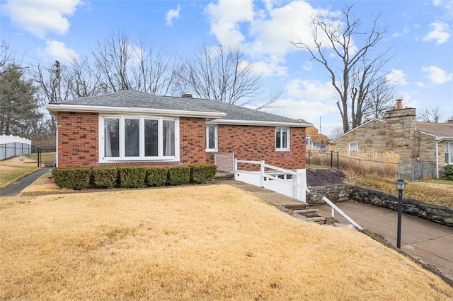 single story home featuring brick siding, an attached garage, fence, driveway, and a front lawn