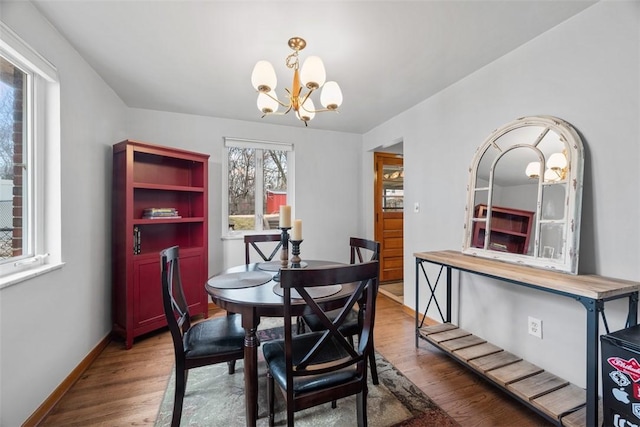 dining area with a notable chandelier, baseboards, and wood finished floors