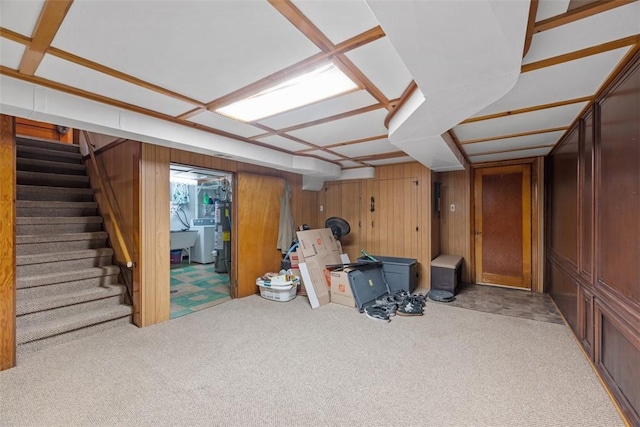 finished basement featuring washer / dryer, carpet, stairs, and wooden walls