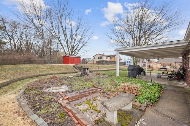 view of yard featuring a storage shed, a fenced backyard, a patio, and an outdoor structure