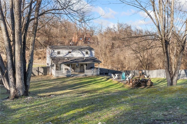 view of yard with covered porch and fence