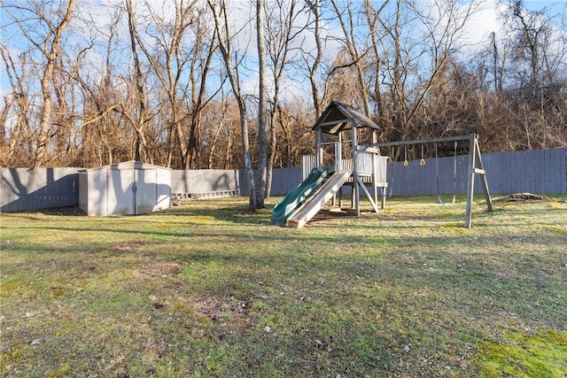 view of playground featuring a storage shed, a lawn, an outdoor structure, and a fenced backyard