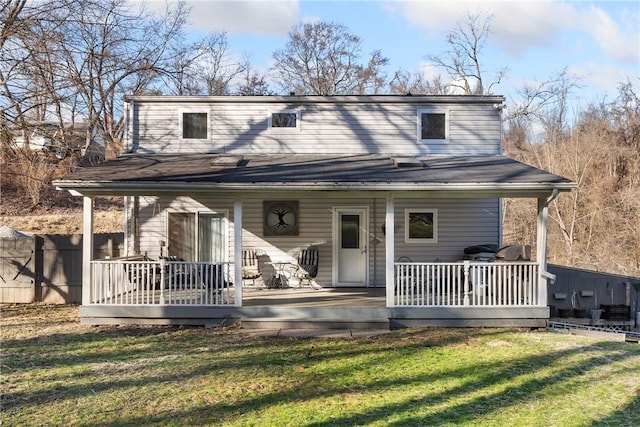 view of front of home featuring fence, a wooden deck, and a front lawn