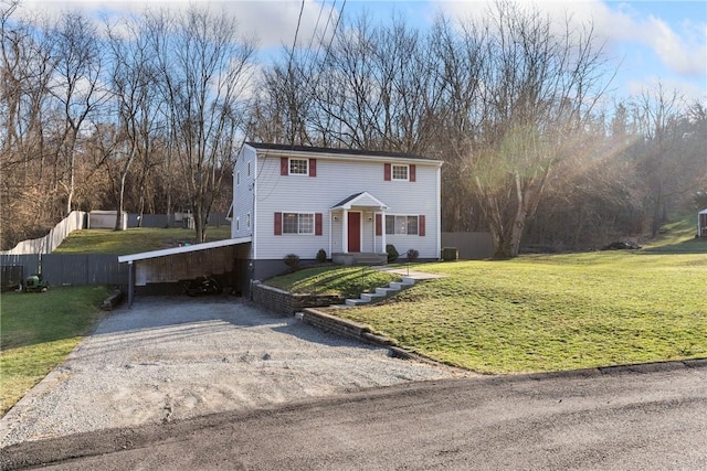 view of front of house featuring a carport, driveway, a front lawn, and fence